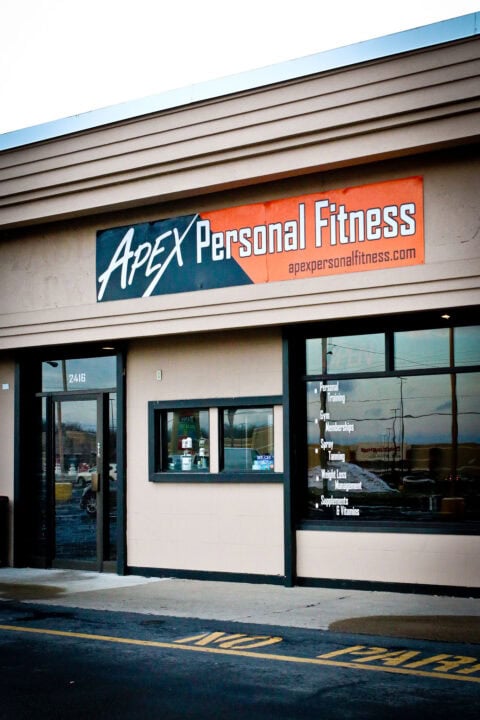 Image of Apex Personal Fitness gym storefront showing signage, windows, entrance door, and parking area.