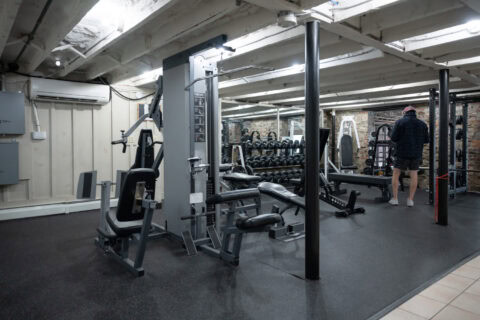 Cable machines and dumbbell rack with member training at Apex Personal Fitness Youngstown NY