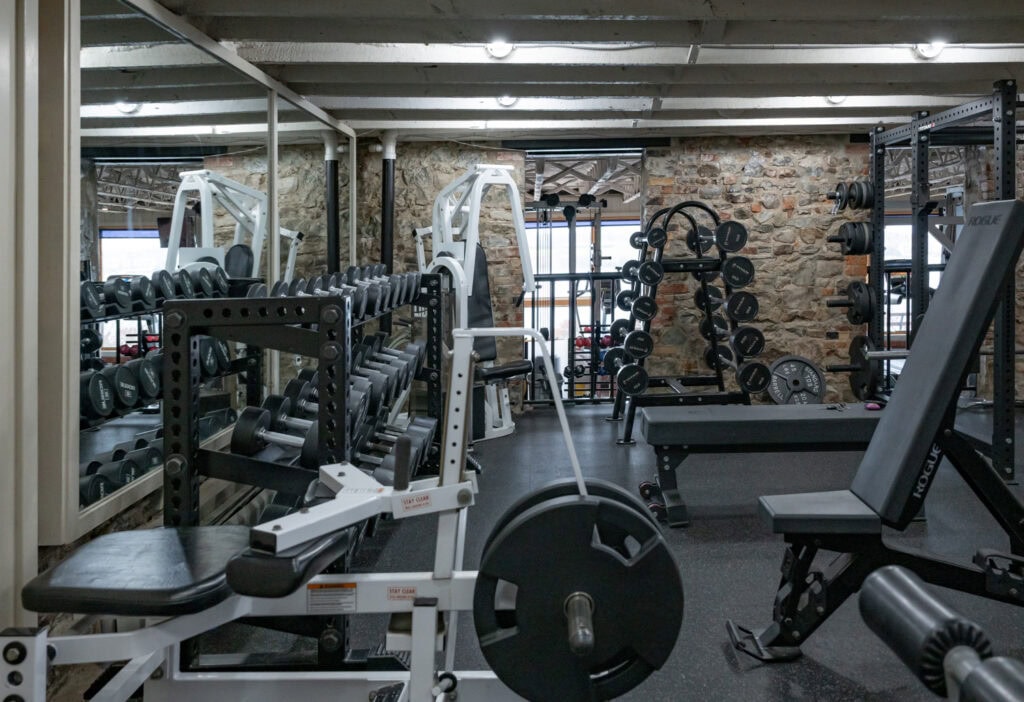 Dumbbells, benches and squat rack in the free weight area at Apex Personal Fitness in Youngstown, NY