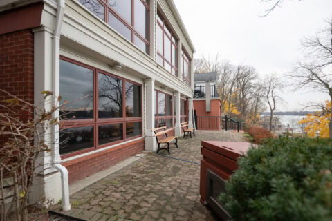Alpine-style outdoor fitness space near water for exercise and relaxation, featuring benches and nature views.