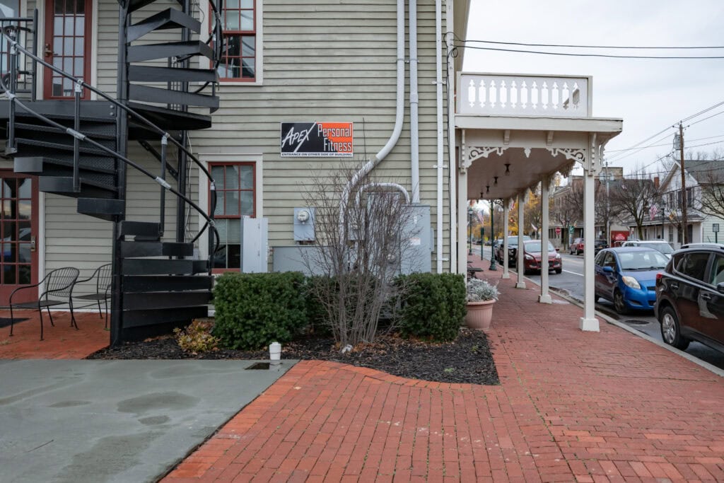Apex Personal Fitness gym exterior with street parking and outdoor seating area.